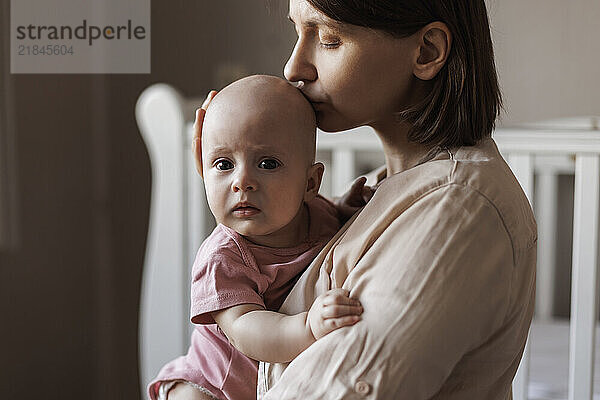 Mother embracing baby at home