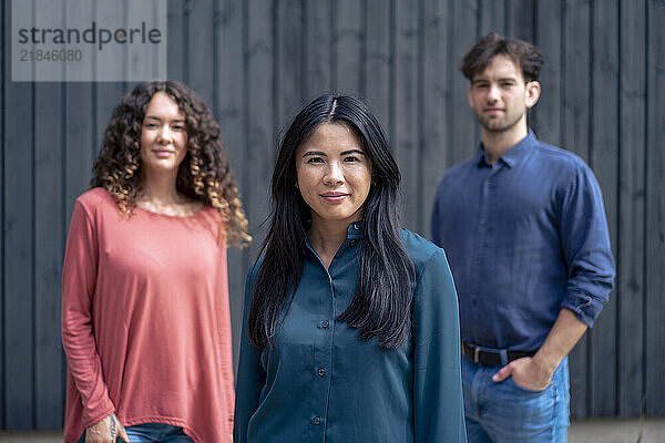 Multiracial friends standing in front of wall