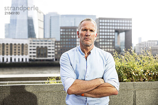 Businessman in blue shirt with arms crossed at London  UK