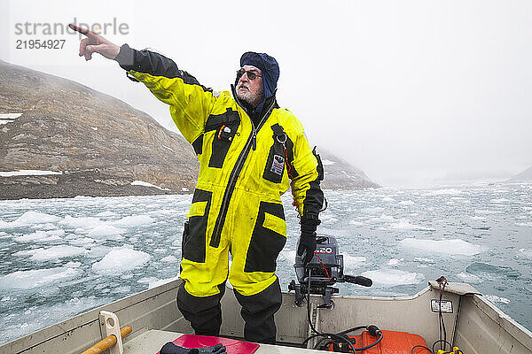 A glaciologist navigates a motorboat through the ice-choked forebay of Paierlbreen glacier  Hornsund  Svalbard.