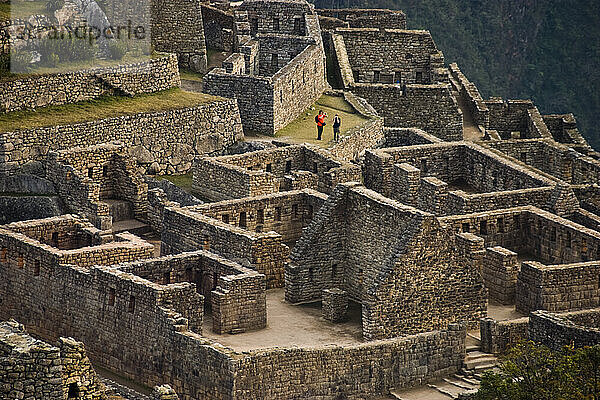 Tourists take pictures at dawn from inside the main ruins of the spectacular archeological site of Machu Picchu  Peru.