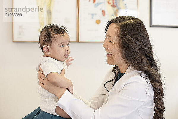 Doctor and baby smiling at each other