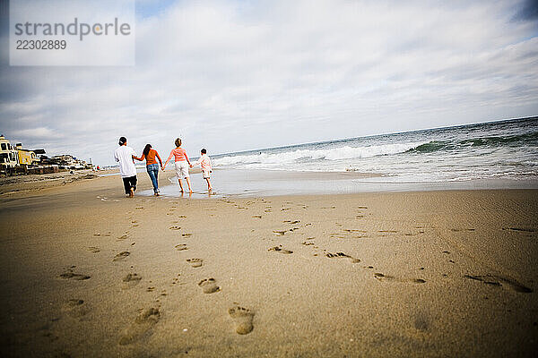 A family walks away on the beach.